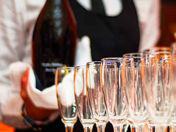 Image of a wedding bartenders serving champagne for a blog post about June wedding ideas and planning for National Bartender Staffing. istockphoto-524698022